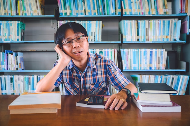 Verveeld Aziatische student met boeken in de bibliotheek