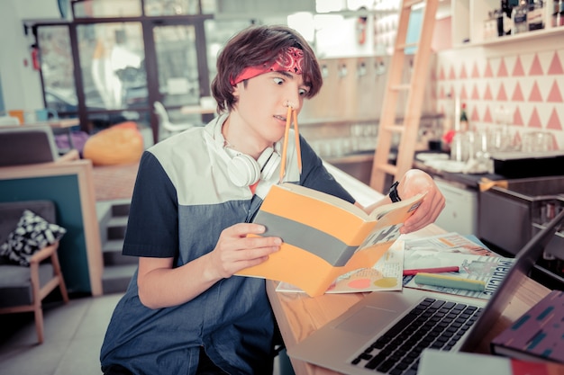 Verveeld zijn. de student is aan het rommelen tijdens de voorbereiding op de toets