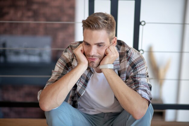 Verveelde man. Een man die zich verveelt en van streek raakt terwijl hij thuis blijft