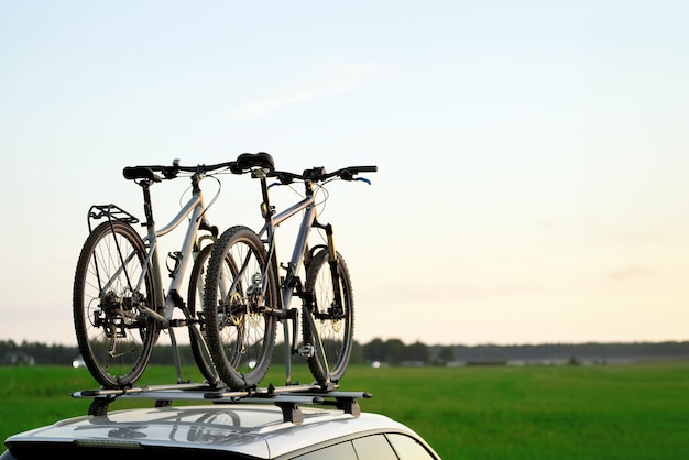 Vervoer van fietsen op het dak van de auto Concept van een zomervakantie op een autorit met een fiets Vervoer van sportuitrusting