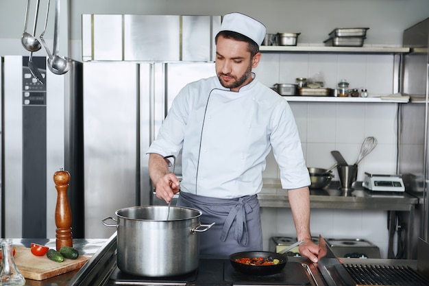 Verwacht de beste chef-kok die een smakelijk gerecht in de keuken kookt