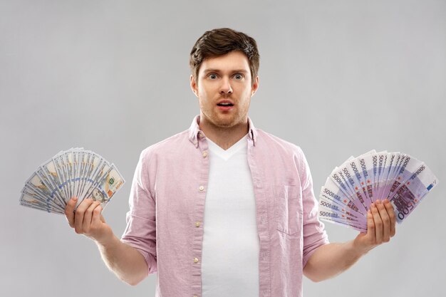 Foto verward jonge man met euro en dollar geld