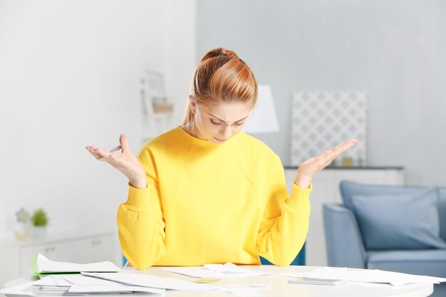 Verwarde jonge vrouw die thuis belastingen berekent