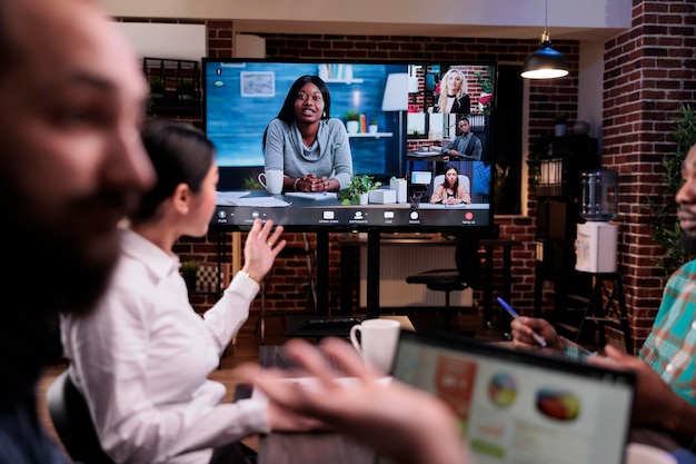 Verwarde startende collega's die praten tijdens een online videoconferentie in een late night meeting, voelen zich moe om overuren te maken. Gemengd team praten over verkoop met externe collega's via internetoproep.