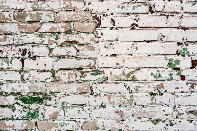 Verweerde textuur van gekleurde oude groene en witte bakstenen muur achtergrond