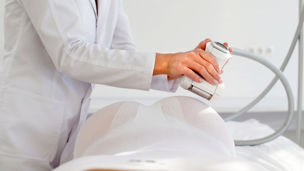 Verwijdering van onderhuids vet door middel van hardware LPG-massage, op probleemgebieden van het lichaam