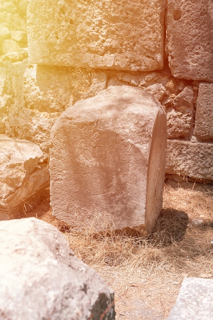 Verwoeste constructie van het oude stenen gebouw met inscripties in de oude taal verken de oude opgravingen van de ruïnes van de oude Lycische stad Phaselis in Turkije in de zomer buiten