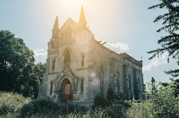 Foto verwoeste kerk op een achtergrond van blauwe hemel zonnestralen schittering in het frame horizontale foto