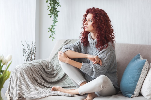 매우 매력적인 젊은 여자가 실내. 곱슬 머리 여자의 초상화입니다. Redhaired 아름 다운 여자 집에서.