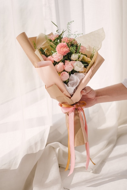 회색 벽 배경에 꽃의 아름 다운 화려한 개화 꽃다발을 들고 매우 아름 다운 꽃집 여자.
