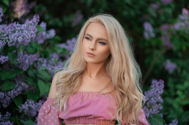 Very beautiful girl in a pink top in purple flowers