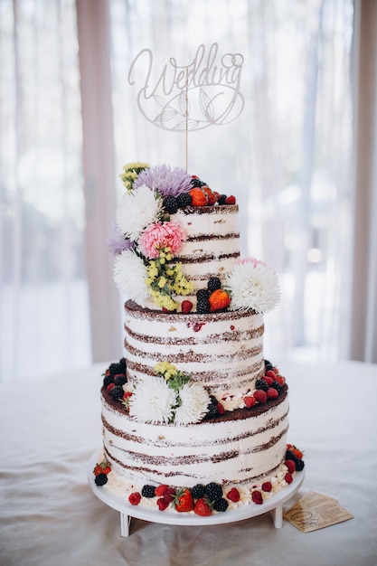 Bellissima torta nuziale rustica decorata con fiori