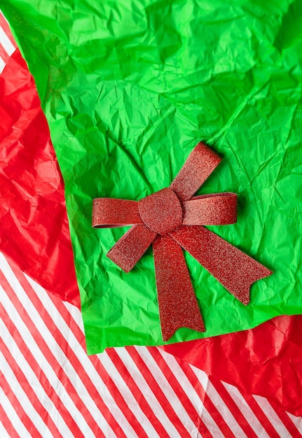 Very beautiful shiny red bow lying on gift paper concept of gift wrapping and Christmas and New Year celebration View from above