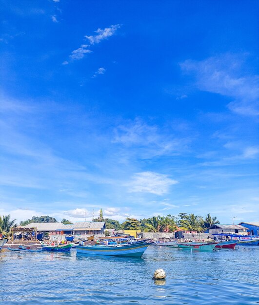 Very beautiful view with calm blue sky water and several boats