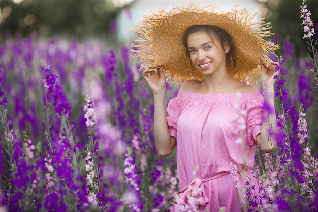 花を持つ非常に美しい若い女性。魅力的な女性のポートレートを閉じます