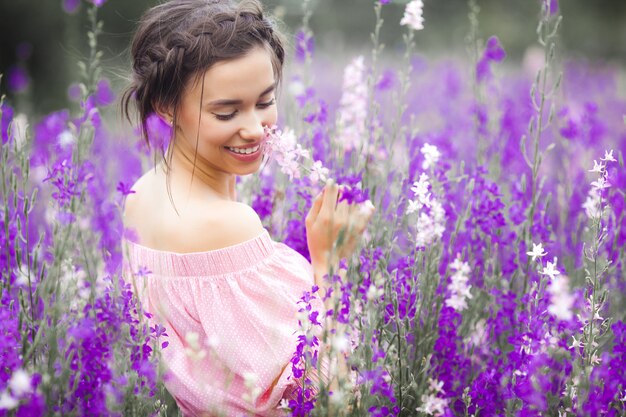 花を持つ非常に美しい若い女性。魅力的な女性のポートレートを閉じます