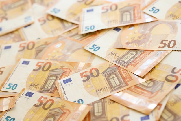 아주 많은 양의 50개의 유럽 유로 지폐가 거대한  ⁇ 어리로 쌓여 있습니다.