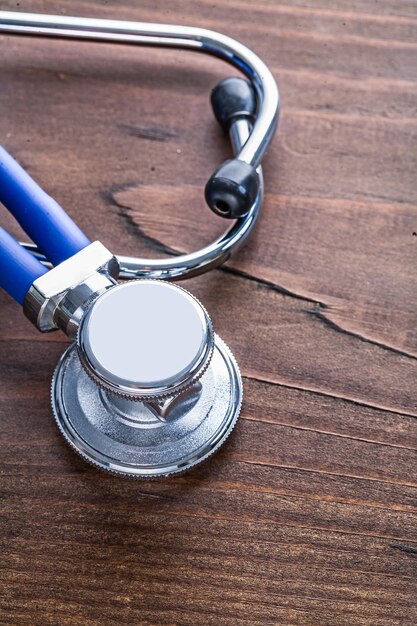 Very close up blue medical stethoscope on vintage wooden board