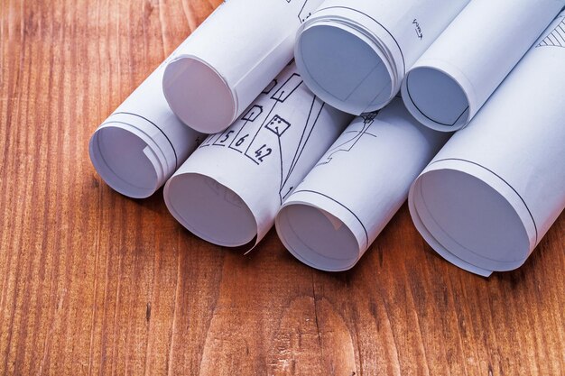 Very close up view on stack of blueprints on old wooden board