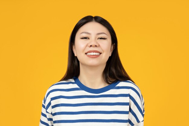 Very cute asian girl closeup portrait on a yellow background