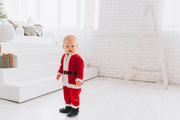 Very cute Caucasian little toddler boy wearing Santa costume