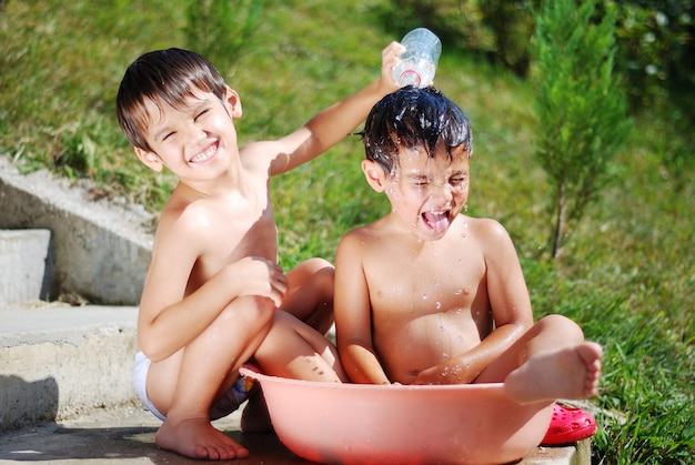 屋外で水遊びするとてもかわいい子供