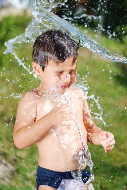 屋外で水遊びするとてもかわいい子供