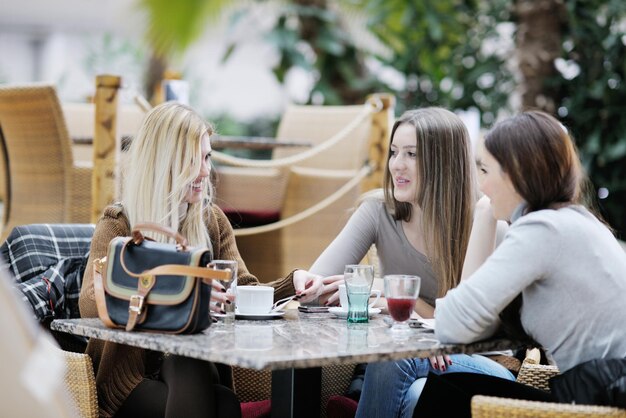 very cute smiling women drinking a coffee sitting inside in cafe restaurant