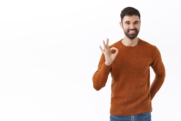 Very good quality I guarantee Portrait of handsome satisfied bearded man showing okay sign and smiling nod in approval recommend good barbershop or store white background