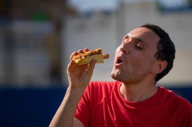 Photo very happy boy eating a hot dog