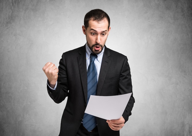 Very happy businessman reading a document