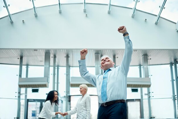 Photo very happy businessman standing in the hall of the business center