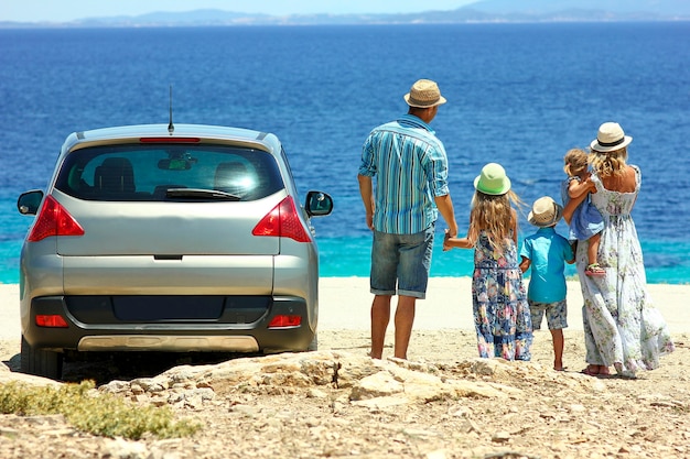 Very happy family by car by the sea