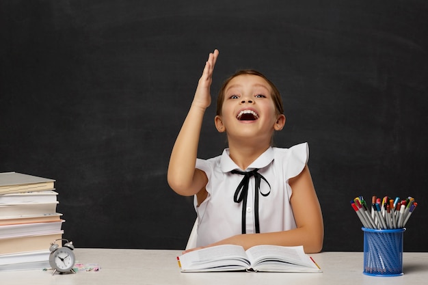 Very happy schoolgirl raised her hand up