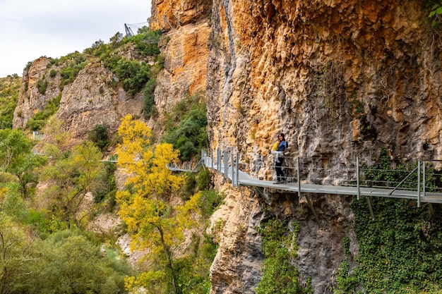 Photo very happy woman and son walking along the metal walkways of the vero river path in alquezar pyrenees