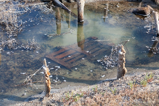 非常にひどく汚染された小川自然の貯水池は人間の経済活動に苦しんでいます