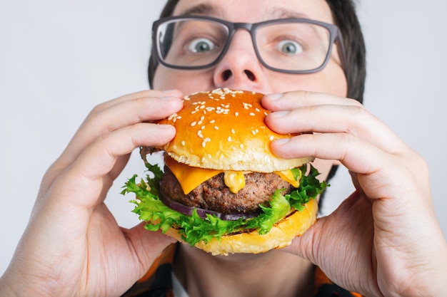 A very hungry student eats fast food.