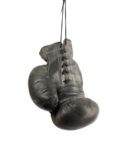 Very old black right boxing glove hanging on a cord isolated 