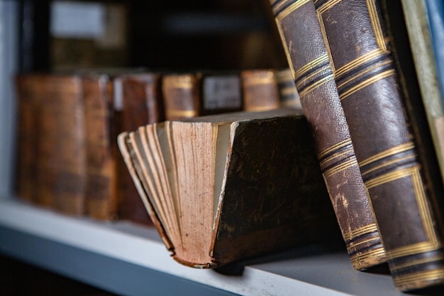 Very old books sitting on the shelves in the library.