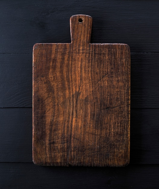 Photo very old brown kitchen cutting board with handle