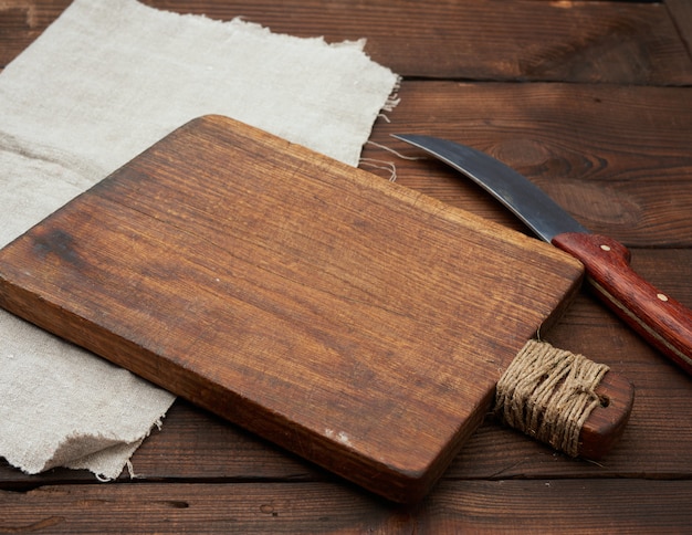 Very old empty wooden rectangular cutting board and knife, top view,