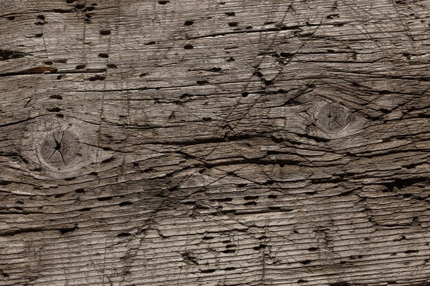 A very old shabby and battered wooden background with deep cuts from a knife and traces of blows