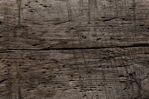 A very old shabby and battered wooden background with deep cuts from a knife and traces of blows