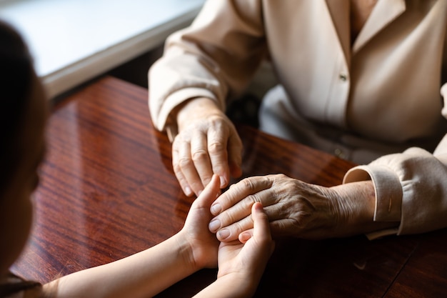 very old woman holding the hands of a child