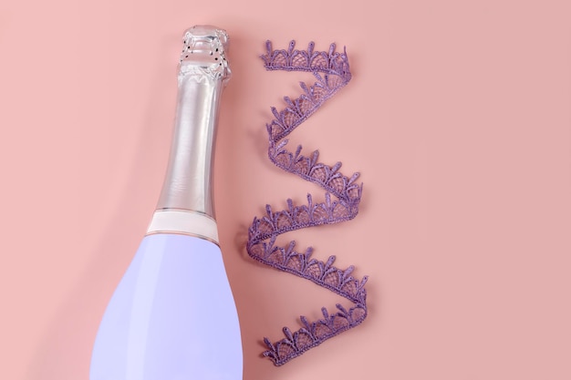 Very Peri champagne bottle on pink background with violet lace ribbon