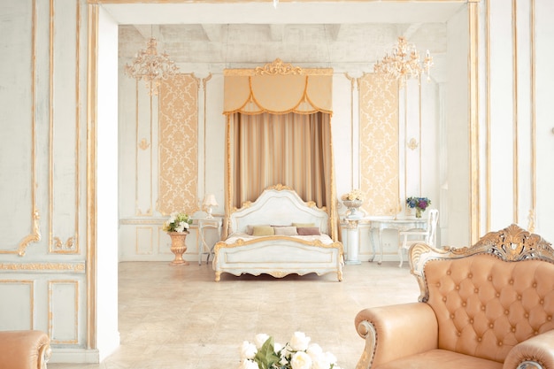 Very rich interior of the apartment with golden decorations on the walls in the Baroque style and luxury furniture with gold paint.