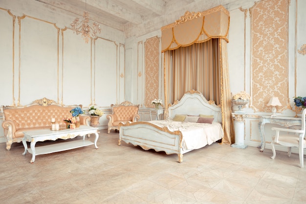 Очень богатый интерьер квартиры с золотыми украшениями на стенах в стиле барокко и роскошной мебелью с золотой краской.