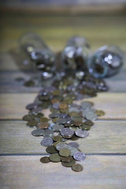 Foto verzamelde munten gestapeld in glazen potten op de vloer