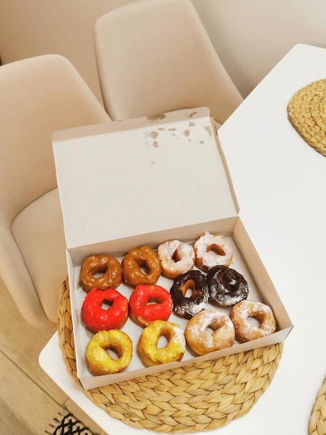 Verzameling donuts op tafel in een doos met boeketten tulpen