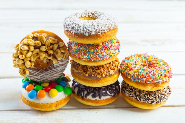 Verzameling van smakelijke donuts op witte houten bord